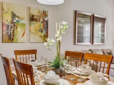 a dining room with a table with white dishes and flowers at Your Home near Disney 19106 in Kissimmee