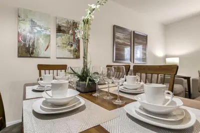 a dining room table with white dishes and wine glasses at Your Home near Disney 19106 in Kissimmee