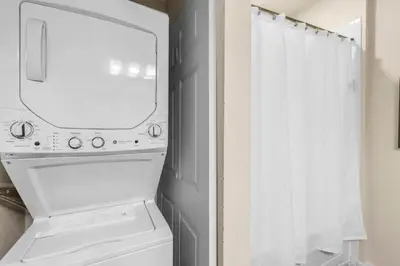 a bathroom with a mirror and a washer and dryer at Your Home near Disney 19106 in Kissimmee