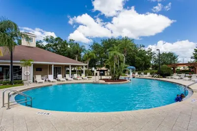 a pool at a resort with chairs and trees at Your Home near Disney 19106 in Kissimmee