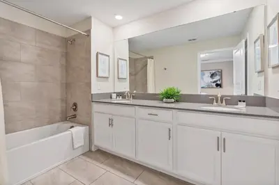 a white bathroom with a tub and a sink and a bath tub at Outstanding 5BDR Disney Vacation in Kissimmee