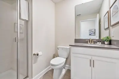 a white bathroom with a toilet and a sink at Outstanding 5BDR Disney Vacation in Kissimmee