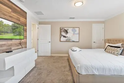 a bedroom with a bed and a flat screen tv at Outstanding 5BDR Disney Vacation in Kissimmee