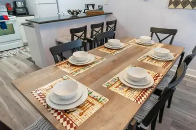 a dining room with a wooden table with white dishes on it at Home Away from Home in Disney 4106 in Kissimmee