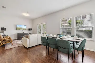 a dining room and living room with a table and chairs at Amazing 4 bdr house near Disney 16101 in Kissimmee