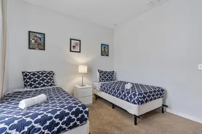 a bedroom with two beds and a lamp in it at Amazing 4 bdr house near Disney 16101 in Kissimmee