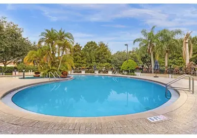 a swimming pool in a park with trees at Amazing 4 bdr house near Disney 16101 in Kissimmee