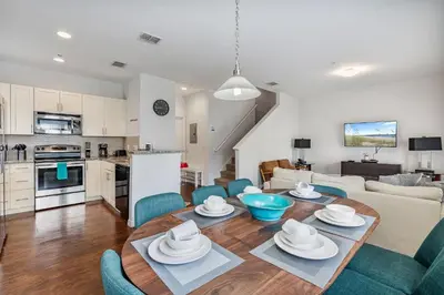 a kitchen and living room with a table and chairs at Amazing 4 bdr house near Disney 16101 in Kissimmee