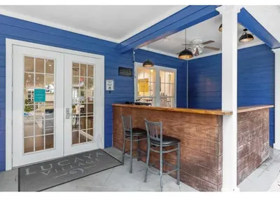 a bar in a blue room with two stools at Amazing 4 bdr house near Disney 16101 in Kissimmee
