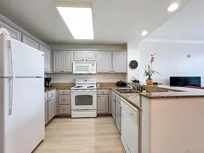 a kitchen with white appliances and a white refrigerator at Beautiful Orlando Lakefront Condo 5 MINUTES FROM DISNEY in Orlando