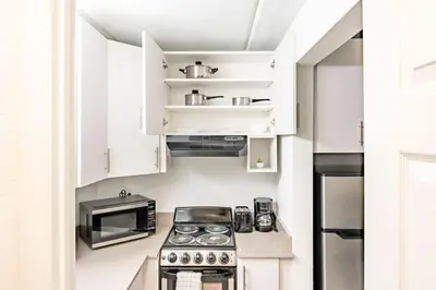 a small kitchen with a stove and a microwave at Luxury and Cozy Gem 15min to Disney Free Parking in Kissimmee