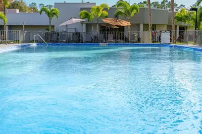 a large pool with blue water in front of a building at Luxury and Cozy Gem 15min to Disney Free Parking in Kissimmee