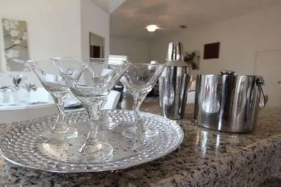 two wine glasses sitting on a plate on a counter at 4BDR with pool near Disney 1014 in Kissimmee