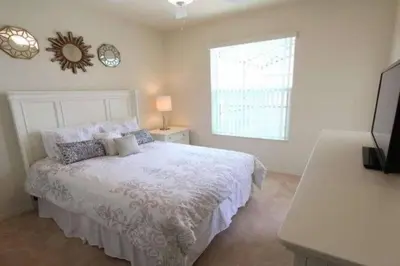 a bedroom with a white bed and a window at 4BDR with pool near Disney 1014 in Kissimmee