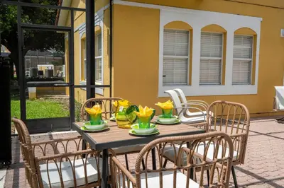 a wooden table with chairs and flowers on a patio at Gorgeous 4Bd w Pool at Encantada Resort 8523 in Kissimmee