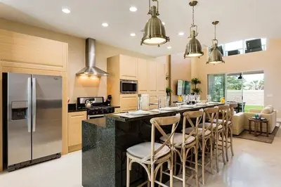 a large kitchen with a bar with stools and a counter top at Super Close to Disney Magic Stays in Orlando