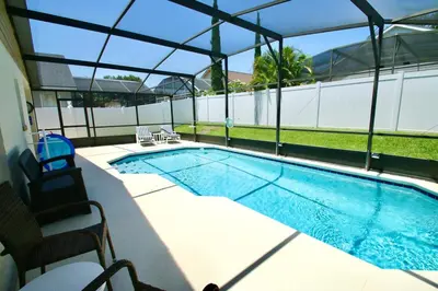 a swimming pool with two chairs next to it at Family Escape Close to parks in Orlando