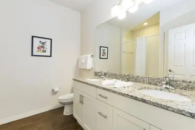 a bathroom with a sink and a toilet and a mirror at Amazing 3Bdr House near Disney 16106 in Kissimmee