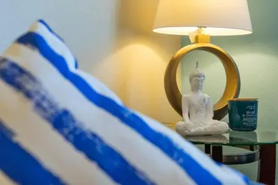 aitating buddha statue sitting on a table next to a mirror at Amazing 3BDR House near Disney 12102 in Kissimmee