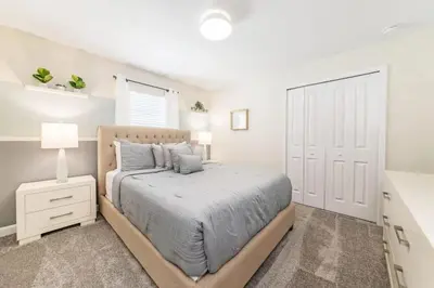 a bedroom with a large bed and a white door at Casa 5 Quartos c/ Piscina Privativa no Storey Lake in Kissimmee