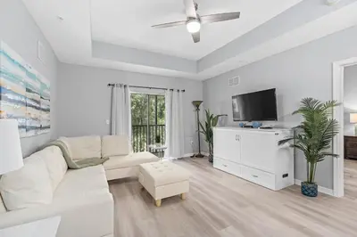 a living room with a white couch and a tv at Finding Nemo House at Caribe Cove Resort - Sage Vacations in Kissimmee