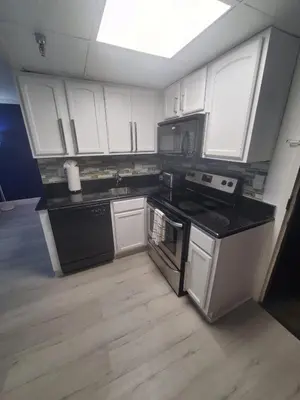 a kitchen with white cabinets and black appliances at Universal-Disney Dream 3413 Studio - The Enclave in Orlando