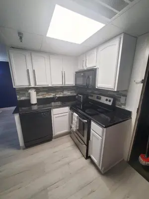 a kitchen with white cabinets and a black stove top oven at Universal-Disney Dream 3413 Studio - The Enclave in Orlando
