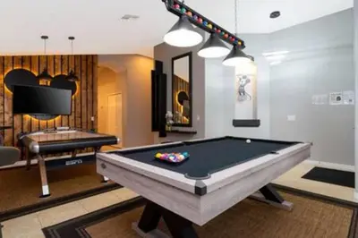 a living room with a pool table and a tv at 4 Bedroom with Pool near to Disney in Kissimmee