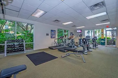 a gym with treadmills and elliptical machines at Beautiful 4 Bedroom Pool Home Near Disney in Kissimmee