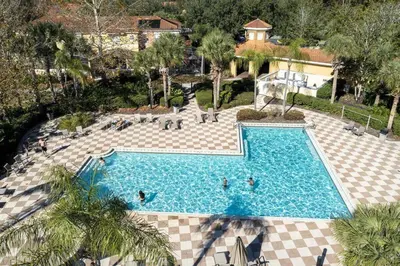 an overhead view of a swimming pool with people in it at Beautiful 4 Bedroom Pool Home Near Disney in Kissimmee