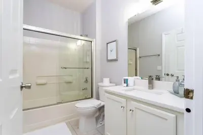 a bathroom with a shower and a toilet and a sink at Beautiful 4 Bedroom Pool Home Near Disney in Kissimmee