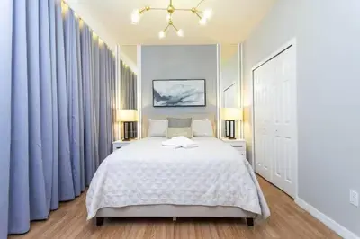 a bedroom with a large bed with blue drapes at Beautiful 4 Bedroom Pool Home Near Disney in Kissimmee