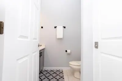 a white bathroom with a toilet and a sink at 3 Bedrooms Home W Pool just 6 miles from Disney in Kissimmee