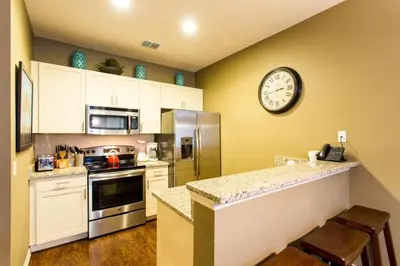 a kitchen with a clock on the wall at Your VIP Home near Disney 25107 in Kissimmee
