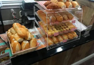 a display case filled with lots of different types of bread at Your VIP Home near Disney 25107 in Kissimmee