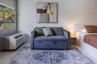 a bedroom with a blue couch and a bed at Sleek and Luxury Studio near Parks with Free Parking in Kissimmee