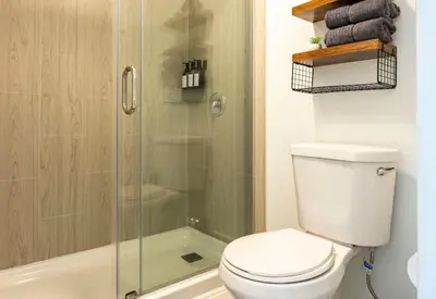 a bathroom with a toilet and a glass shower at Sleek and Luxury Studio near Parks with Free Parking in Kissimmee