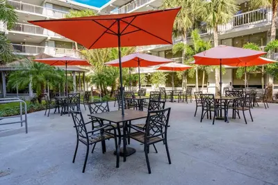 a group of tables and chairs with umbrellas at Sleek and Luxury Studio near Parks with Free Parking in Kissimmee