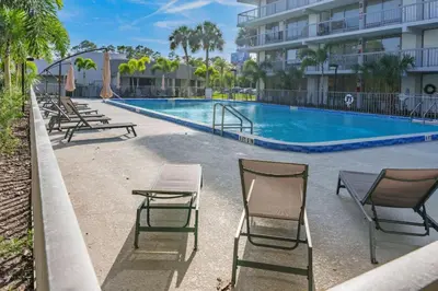 a swimming pool with chairs and a table at Sleek and Luxury Studio near Parks with Free Parking in Kissimmee