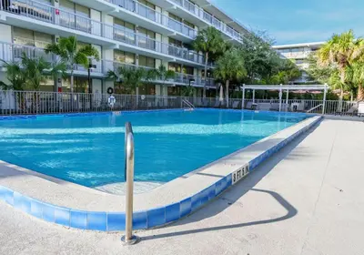 a large blue swimming pool in front of a building at Sleek and Luxury Studio near Parks with Free Parking in Kissimmee