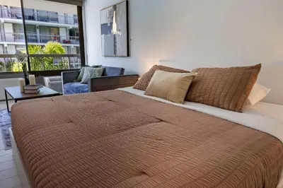 a bedroom with a large bed and a living room at Sleek and Luxury Studio near Parks with Free Parking in Kissimmee