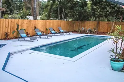 a swimming pool with chairs in a backyard at Exquisite Luxury Villa with Pool in Prime Location in Orlando