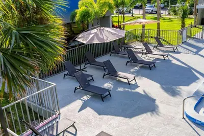 a group of chairs and umbrellas on a patio at Modern 1BED 1BA Gem in Great Location Free Parking in Kissimmee