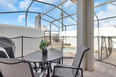 a patio with a table and chairs on a balcony at Your 5BDR house with pool - 4959 in Kissimmee