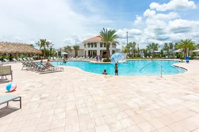 a pool at a resort with people playing in it at Your 5BDR house with pool - 4959 in Kissimmee