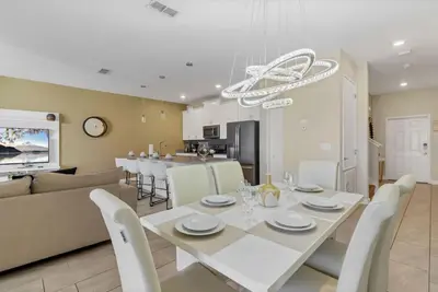 a dining room and living room with a white table and chairs at Amazing 4BDR with pool near Disney - 4914 in Kissimmee