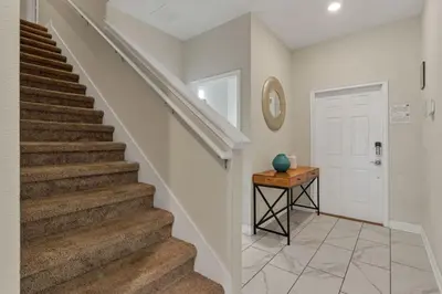 a staircase in a home with a door and a table at Your 4BDR Vacation Home - 4838 in Kissimmee