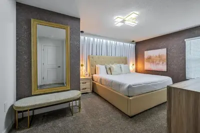 a bedroom with a large bed and a mirror at Casa Temática c/ Piscina no Storey Lake in Kissimmee