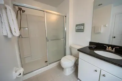 a bathroom with a shower and a toilet and a sink at Villa Bella - 4 Bedrooms in Kissimmee