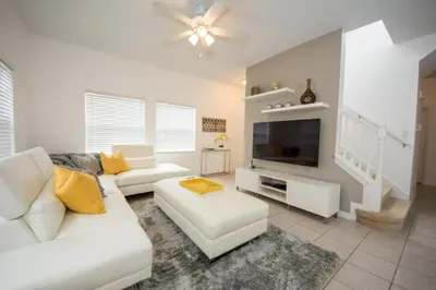 a living room with a white couch and a tv at Villa Bella - 4 Bedrooms in Kissimmee
